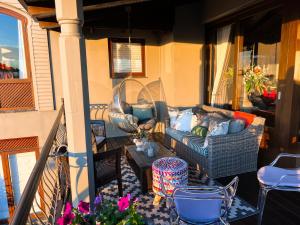 porche con sofá y mesa en el balcón en Pezula Magic Escape - Guest House - No Loadshedding, en Knysna