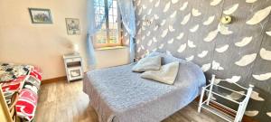 Un dormitorio con una cama y una pared con corazones en La Chevrie, en Les Oubeaux