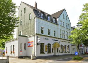 a white building on the corner of a street at Hotel Haus Kleimann-Reuer in Gladbeck