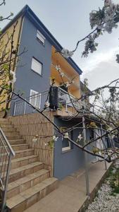 a blue and yellow building with stairs and a balcony at Apartments New Charming in Senj