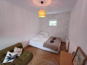 Ranndi Terras - Yourhosthelper conciergerie في لانستير: غرفة نوم صغيرة مع سرير وأريكة