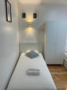 Bett in einem kleinen Zimmer mit Deckenlicht in der Unterkunft Apartamento Pensamento Inédito 55 in Lissabon