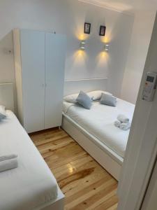 ein kleines Schlafzimmer mit 2 Betten und Holzböden in der Unterkunft Apartamento Pensamento Inédito 55 in Lissabon