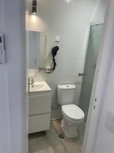 uma casa de banho branca com um WC e um chuveiro em Apartamento Pensamento Inédito 55 em Lisboa