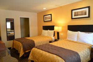 una camera d'albergo con due letti e pareti gialle di Enfield Inn a Enfield