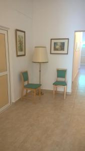 two chairs and a table and a lamp in a room at Vila Puskin - Eforie Sud in Eforie Sud
