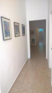 a hallway with white walls and pictures on the wall at Vila Puskin - Eforie Sud in Eforie Sud