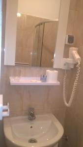 a bathroom with a sink and a mirror and a phone at Vila Puskin - Eforie Sud in Eforie Sud