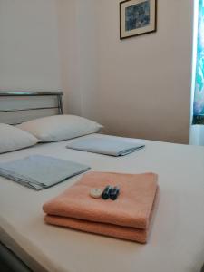 a bed with a towel and a laptop on it at Vila Puskin - Eforie Sud in Eforie Sud