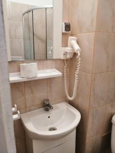 a bathroom with a sink and a phone on the wall at Vila Puskin - Eforie Sud in Eforie Sud