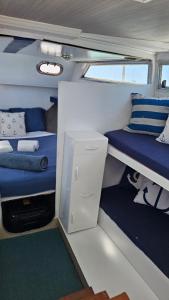 Habitación pequeña con cama y escritorio en un barco en Tarasmaki - Boat House, en Ilha da Culatra