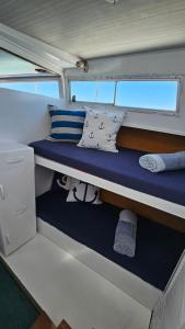 un estante en la parte trasera de un barco con almohadas en Tarasmaki - Boat House, en Ilha da Culatra