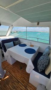 een boot met een tafel en stoelen op een boot bij Tarasmaki - Boat House in Ilha da Culatra