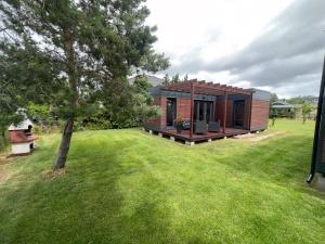 a tiny house in a yard with a tree at BLUE BAY in Mosty