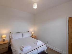 a bedroom with a bed with white sheets and towels at Church View - Pass the Keys in Ferryhill