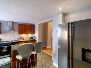 a kitchen with a stainless steel refrigerator and stools at Church View - Pass the Keys in Ferryhill