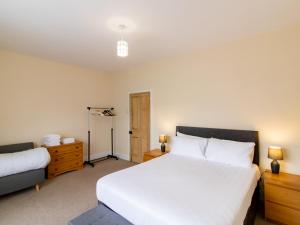 a bedroom with a large white bed and a dresser at Church View - Pass the Keys in Ferryhill