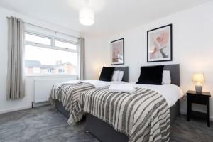 a bedroom with two beds and a window at Tithe Barn House in Stockton-on-Tees