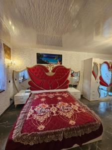 sypialnia z dużym łóżkiem z czerwoną narzutą w obiekcie Willa Aurelcia w Świnoujściu