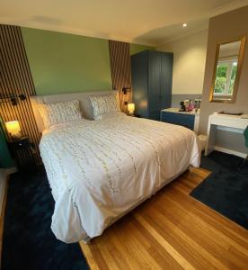een slaapkamer met een wit bed en een bureau bij Westwood - The B&B with a view in Cockermouth
