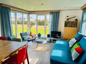 米茨兰Chalet Kocky的客厅里有一张蓝色的沙发和椅子