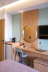 a bedroom with a desk with a mirror and a chair at Arocaria Apartments in Chania Town