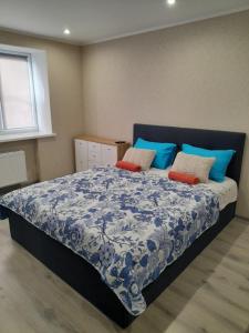 a bedroom with a blue and white bed with pillows at Kandavas Apartments in Daugavpils