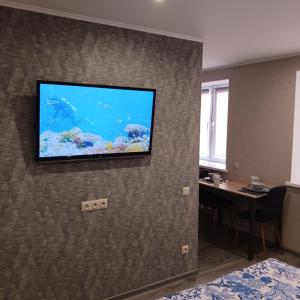 een flatscreen-tv aan een muur in een hotelkamer bij Kandavas Apartments in Daugavpils