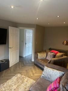 a living room with a couch and a door at Lovely 2 Bed, detached home. in Seacroft