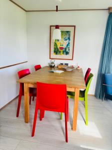 a dining room table with red and green chairs at Chalet Kocky in Midsland