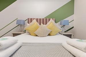 a bedroom with a white bed with yellow pillows at Stunning 2-Bed Apartment Fully Equipped - Clapham Junction - Battersea - 5 Minutes Train Station in London
