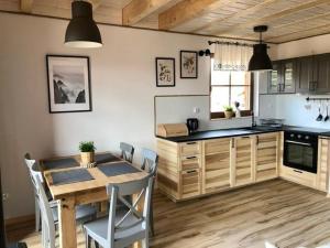 a kitchen with a wooden table and a dining room at Ostoja Bukowo Prime in Borowy Młyn