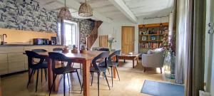 a kitchen and dining room with a wooden table and chairs at La Source in Saint-Cybranet