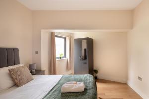 Charming Two-Bedroom Retreat in Morden SM4, London في Morden: غرفة نوم بسرير كبير ونافذة
