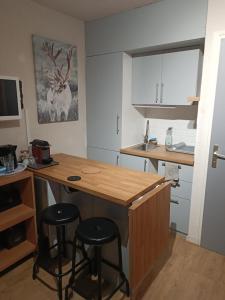 a kitchen with a wooden counter and stools in it at Studio au pied des pistes avec vue sur la montagne in Mieussy