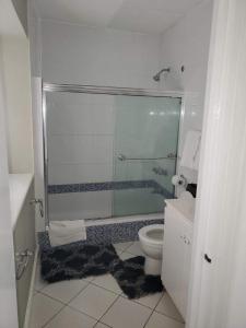 a bathroom with a toilet and a glass shower at Sunset condos getaway In Ocho Rios in Ocho Rios