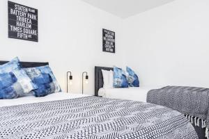 a bedroom with two beds with blue and white pillows at K Suites - Shetland Court in Bridgwater