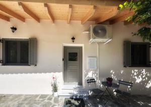 a white building with a door and chairs and a table at Lemon House in Nafplio