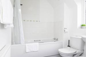 baño blanco con bañera y aseo en K Suites - Shetland Court, en Bridgwater