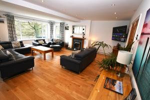 sala de estar con muebles negros y chimenea en Borrowdale View en Keswick