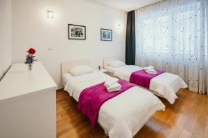 two beds in a room with a sink at Apartment Vijećnica in Sarajevo