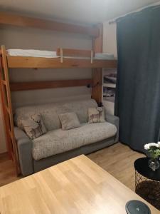 a couch in a room with a bunk bed at Studio au pied des pistes avec vue sur la montagne in Mieussy