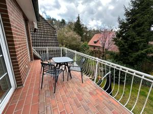 a patio with a table and chairs on a balcony at Heideidyll - Geräumige Wohnung mit Balkon & Garage in Schneverdingen