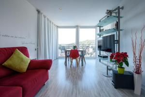 a living room with a red couch and a table at Apartamento Reisol in Castelldefels