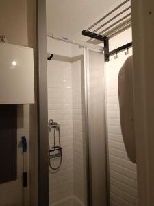 a bathroom with a shower with a white tile wall at Studio au pied des pistes avec vue sur la montagne in Mieussy