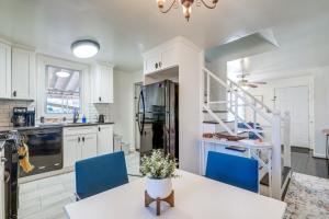 a kitchen with white cabinets and a table and blue chairs at Updated Arlington Townhome about 5 Mi to National Mall in Arlington