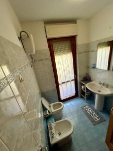 a bathroom with a toilet and a sink at Apartment with private parking spot in Oristano's city center in Oristano