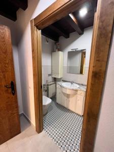 a bathroom with a toilet and a sink and a mirror at Apartamento dúplex en Sangüesa de 3 dormitorios y 2 baños in Sangüesa