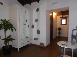特罗尔La Casa de Arriba, private rooms in Teror, Gran Canaria的带白色橱柜和桌子的客厅