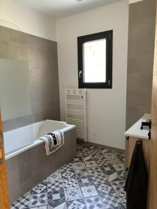 a bathroom with a bath tub and a window at Appartement 2 personnes in Vico